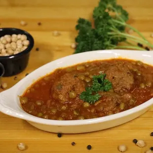 a bowl of stew with beans and broccoli