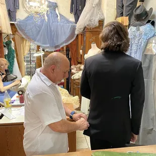 Joyce making alterations and Marv cutting the tacking seams.