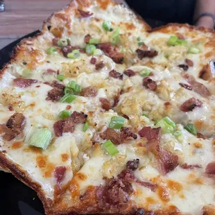 a slice of pizza on a black plate