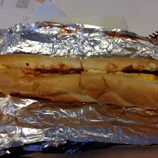 Bacon egg and cheese on a long roll with salt pepper and ketchup