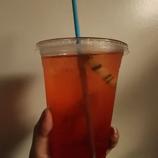 a person holding a drink in a plastic cup