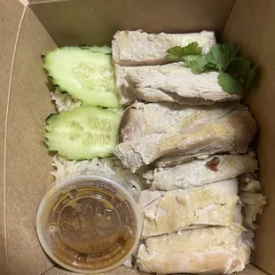 chicken rice and cucumbers in a box