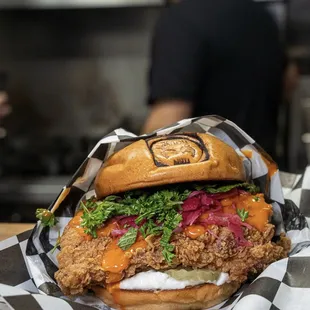 a chicken sandwich wrapped in black and white checkered paper