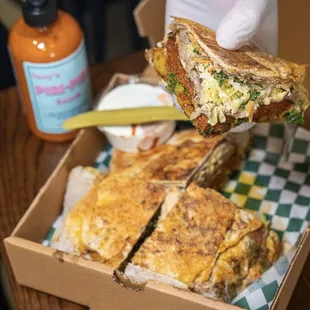 a person holding a sandwich in a box