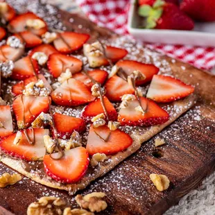 sliced strawberries and walnuts on a cutting board