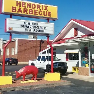 a red pig statue in front of a restaurant
