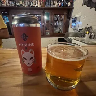 a glass of beer next to a can