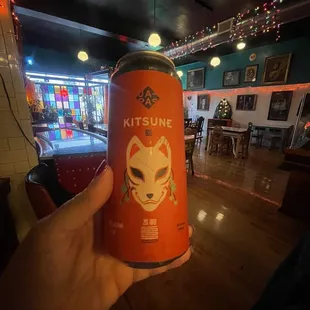 a person holding a can of beer