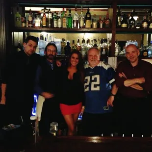 a group of people standing in front of a bar