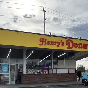 a man standing in front of a donut shop