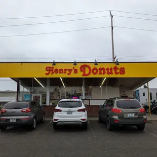 three cars parked in front of a donut shop