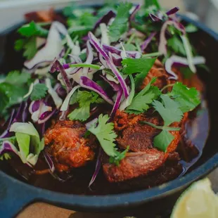 a skillet of meat and vegetables