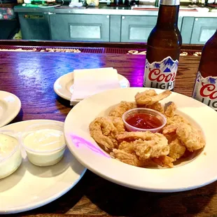 a plate of fried shrimp and two bottles of beer