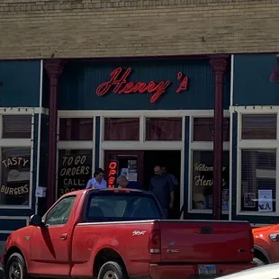 a red pickup truck parked in front of the restaurant