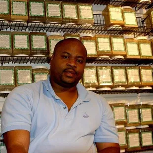a man standing in front of a shelf of boxes