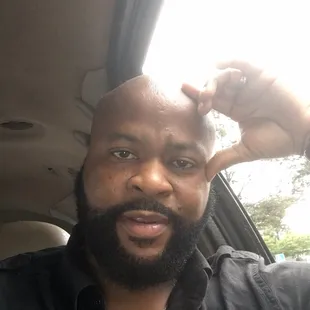 a man in a car with his hand on his head