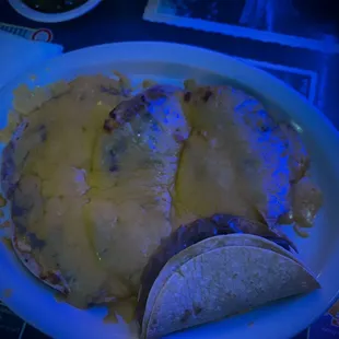 This dark photo with blue twinkle-lighting doesn't do these delicious bean and cheese nachos justice.