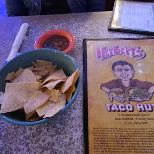 a bowl of chips and a menu