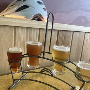 four glasses of beer and a helmet