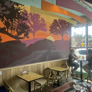 two people sitting at tables in a restaurant
