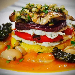 Polenta and Vegetable Napoleon Stack with Herbed Cashew Cream. Maitake Mushroom and Tomato-Saffron Coulis, Butter Beans and Roasted Kale