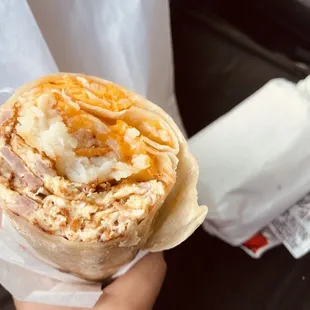 a hand holding a burrito