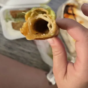 a hand holding a half eaten sandwich