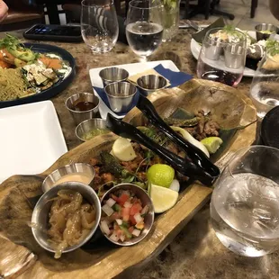 Tacos with 2 meats and fresh warm tortillas on the side for you to BYOT...with sautéed onions, fried serranos, 3 type of salsas.