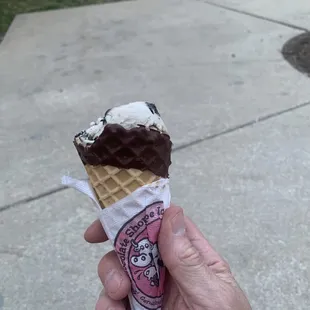 a hand holding an ice cream cone