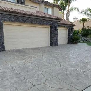 Concrete driveway and stone veneer installed by Heritage Bomanite.