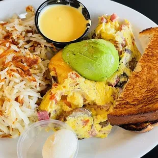 a breakfast plate with eggs, toast, hash browns, and an avocado