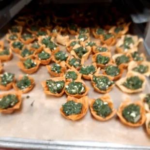 a tray of appetizers being taken out of an oven