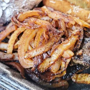 a steak and fries in a styrofoam container