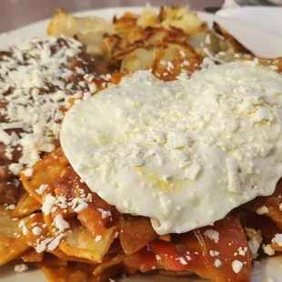 Chilaquiles with beans, potatoes and over medium eggs
