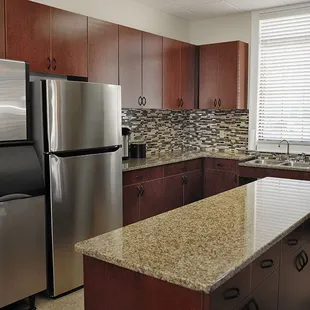 Convenient catering kitchen with large serving window, industrial food warming cabinet,  industrial icemaker and dishwasher.