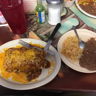 Pollo burrito with chili sauce and cheese guacamole and sour cream. Rice and beans