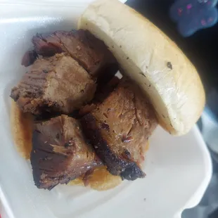 a beef sandwich in a styrofoam container