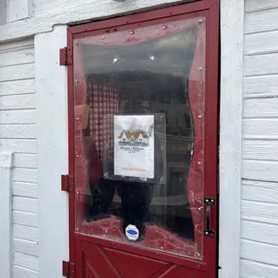 a red door with a sign in the window