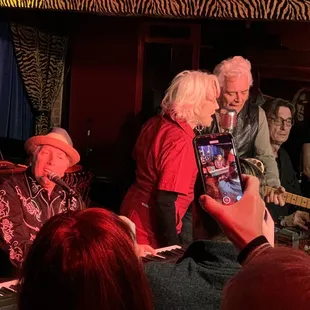 shows a group of people taking pictures of a musician