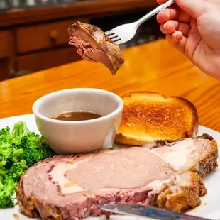 a plate of food with meat, bread, and broccoli