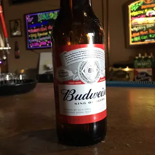 a bottle of budweier beer on a bar