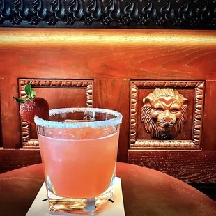 a drink with a strawberry garnish