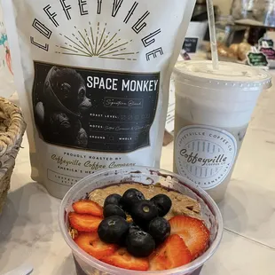 Happy customer with a smoothie bowl, iced late with sweet cold foam and a bag of coffee to take home!