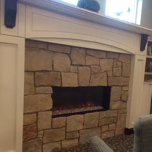 Tucked away in back area of dining is a fireplace and little sitting nook, with bookshelves (not seen) on either side of fireplace.