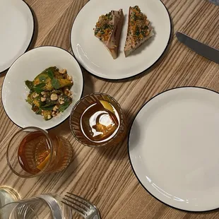 a table with plates of food and a glass of wine