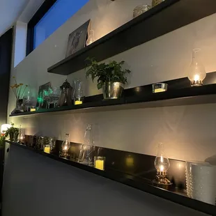 a shelf with candles and vases on it