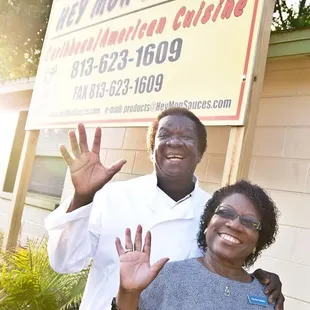 a man and woman standing in front of a sign