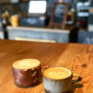 two cups of coffee on a wooden table