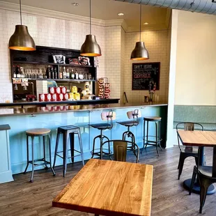a view of a bar with stools and tables
