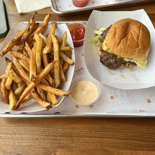 House burger and plate of fries with a side of  buffalo ranch sauce.
